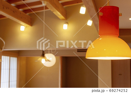 オレンジ色のペンダントライトごしの部屋の写真素材