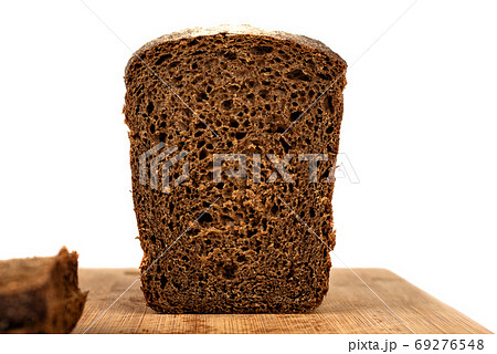 A loaf of rye bread in a cut on a cutting board. A loaf of rye bread in a cut on a cutting board. 69276548