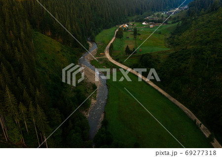 Carpathian river Bila Tisa, the largest tributary of the Danube, Ukrainian mountain river, top view of the river and the road In the village of Luhy. 69277318