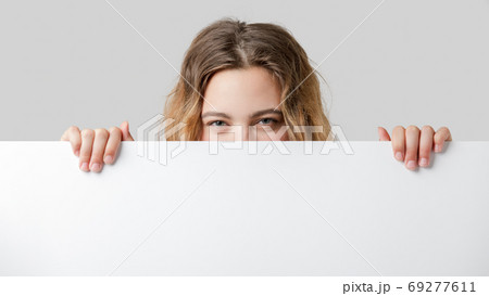 16 year old teenager looks at the camera over a white partition 69277611