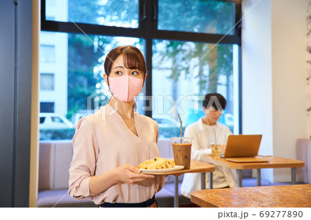 マスクをしてカフェにいる若い女性客 マスクをしてカフェにいる若い女性客 69277890