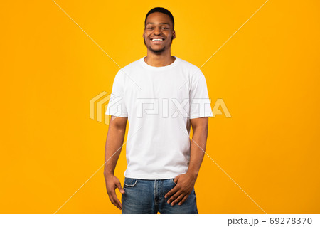Black Man Smiling To Camera Posing, Yellow Background, Studio Shot 69278370