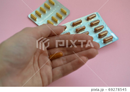 oblong oval tablet in a female palm with manicure. oblong oval tablet in a female palm with manicure. 69278545