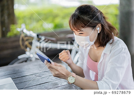 woman wears earbud use smartphone woman wears earbud use smartphone 69278679