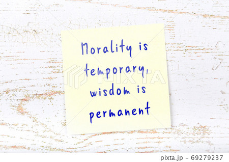 Yellow sticky note on wooden wall with wise quote 69279237