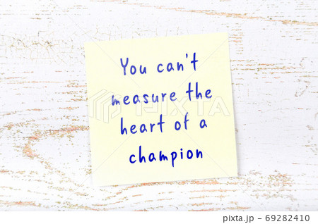 Yellow sticky note on wooden wall with wise quote Yellow sticky note on wooden wall with wise quote 69282410