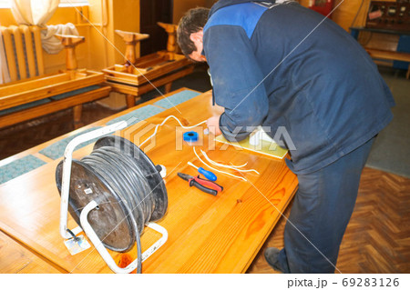 A man working electrician works, collects A man working electrician works, collects 69283126