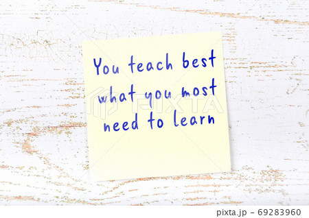 Yellow sticky note on wooden wall with wise quote 69283960