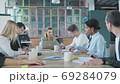 Business woman leader holds meet up with colleagues at a large office table in a loft style. Creative interior. Coworking startup team. Office workers 69284079