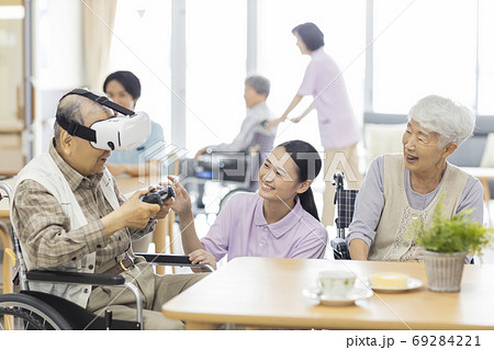 VRのゲームをするシニア男性と介護士 老人ホーム 69284221
