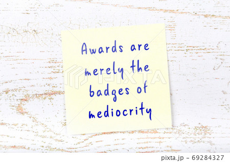 Yellow sticky note on wooden wall with wise quote 69284327