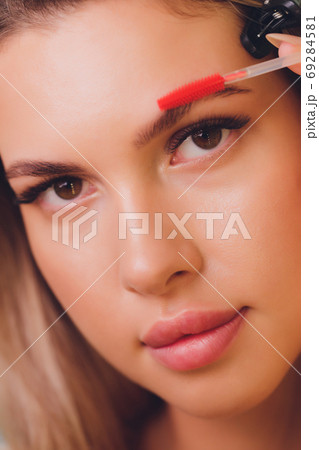 Young woman having professional eyebrow correction procedure in beauty salon. 69284581