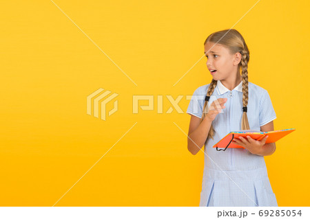 Some troubles. Cute small child reading book on yellow  69285054