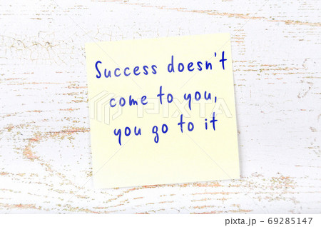 Yellow sticky note on wooden wall with wise quote 69285147