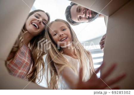 Happy family opening a cardboard and looking excited 69285302