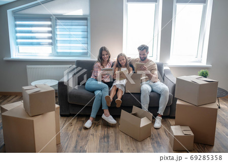 Young family sitting in the new home and looking at the photographs Young family sitting in the new home and looking at the photographs 69285358