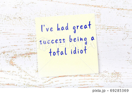 Yellow sticky note on wooden wall with wise quote 69285369