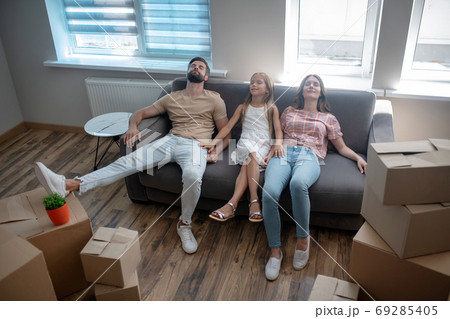Family sitting on the sofa and looking tired Family sitting on the sofa and looking tired 69285405