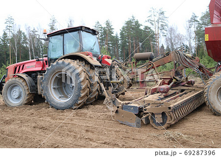 A powerful red tractor with a connected seeding 69287396