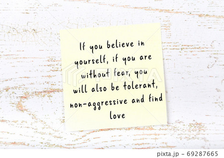 Yellow sticky note on wooden wall with wise quote 69287665