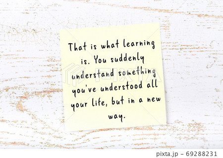 Yellow sticky note on wooden wall with wise quote 69288231