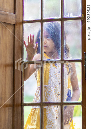 Brunette girl behind wooden and glass door Brunette girl behind wooden and glass door 69289381