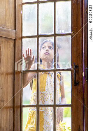 Brunette girl behind wooden and glass door Brunette girl behind wooden and glass door 69289382