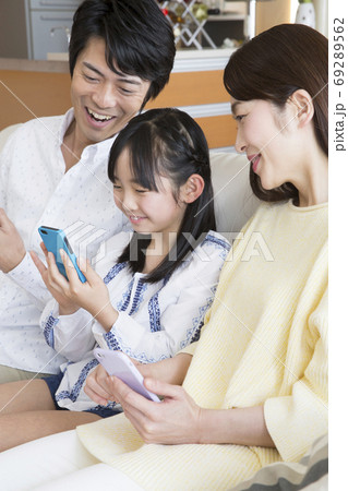スマートフォンを見る家族 スマートフォンを見る家族 69289562