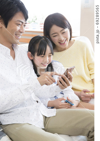 スマートフォンを見る家族 69289565