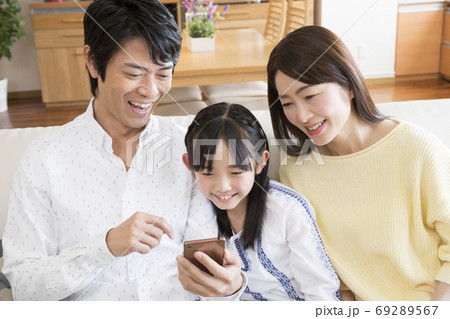 スマートフォンを見る家族 69289567