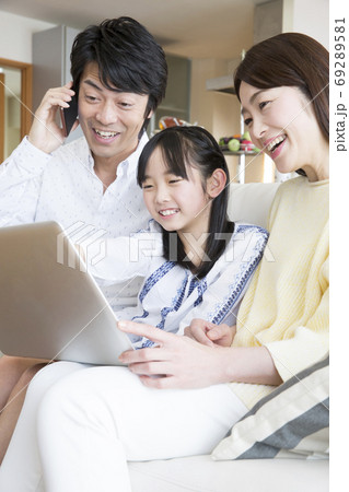 パソコンを見ながら電話をする家族 69289581