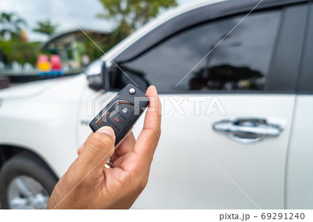 Hand pressing the button on the remote to lock or unlock the car 69291240