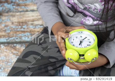 Little girl waking up with an alarm clock 69291419