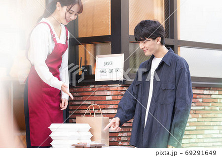 店頭販売をするエプロン姿の店員とお客 69291649