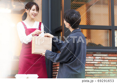 店頭販売をする女性店員とお客 店頭販売をする女性店員とお客 69291653