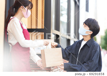 店頭販売をするマスク姿の店員とお客 69291658