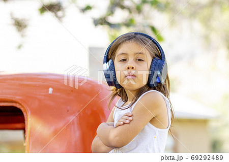 Little girl listening to music with her headphones in the truck Little girl listening to music with her headphones in the truck 69292489