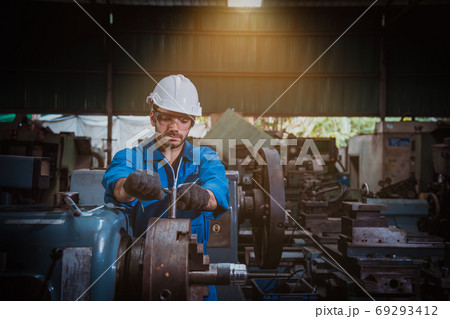 The Industry engineering wearing safety uniform used Vernier caliper to measure the object control operating machine working in industry factory 69293412