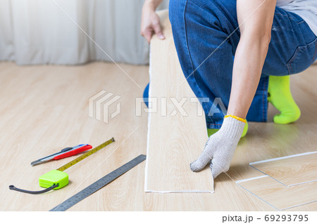 male worker hands replacing laminated wooden floor. home renovation, decoration concept 69293795