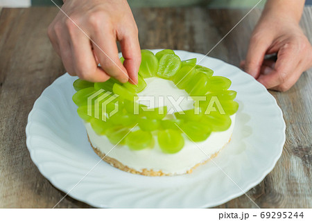 シャインマスカットのレアチーズケーキ作りする女性の手元/デコレーション 69295244