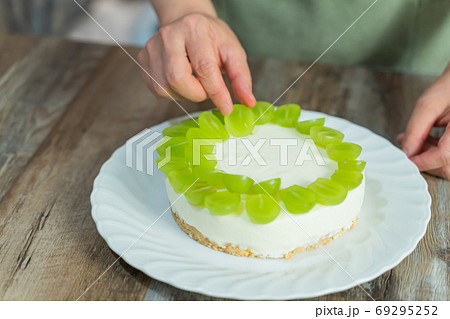 シャインマスカットのレアチーズケーキを作る女性の手元 デコレーション シャインマスカットのレアチーズケーキを作る女性の手元 デコレーション 69295252