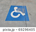 Blue sign on the asphalt about disabled parking 69296405