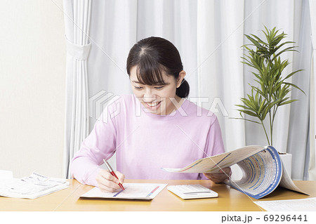 笑顔で確定申告の準備をする女性 69296441