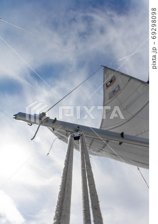 Bottom view of mast and sail of yacht on blue sky backdrop, selective focus 69298098