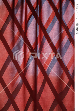 Red wavy natural fabric curtain over wooden partition made of bamboo slats, natural oriental decor 69298305