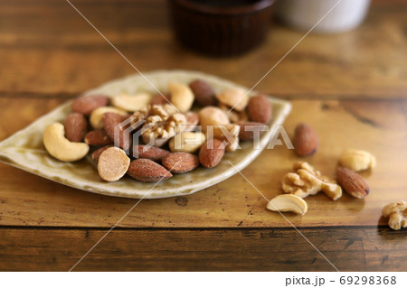 葉っぱの形の皿に盛られたミックスナッツ 69298368