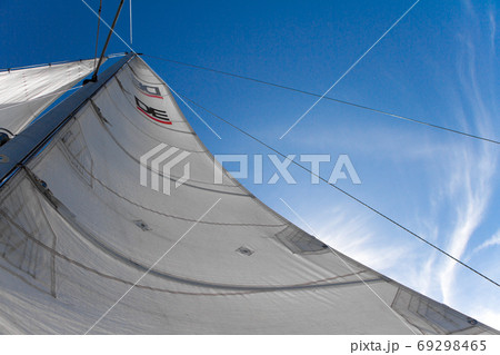 Bottom view of mast and sail of yacht on blue sky background, selective focus Bottom view of mast and sail of yacht on blue sky background, selective focus 69298465