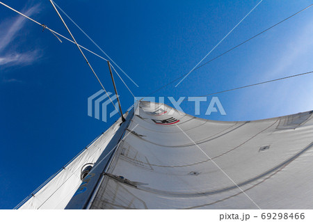 Bottom view of mast and sail of yacht on blue sky background, selective focus 69298466