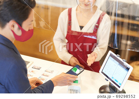 感染症対策をした店でキャッシュレス決済をする男性客と女性店員 69298552