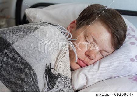 Mature brunette woman sleeping in bed under plaid blanket, illness or cold concept , selective focus Mature brunette woman sleeping in bed under plaid blanket, illness or cold concept , selective focus 69299047